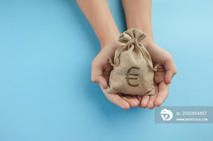 Women hold a money bag on blue background, Saving money for future investment concept.