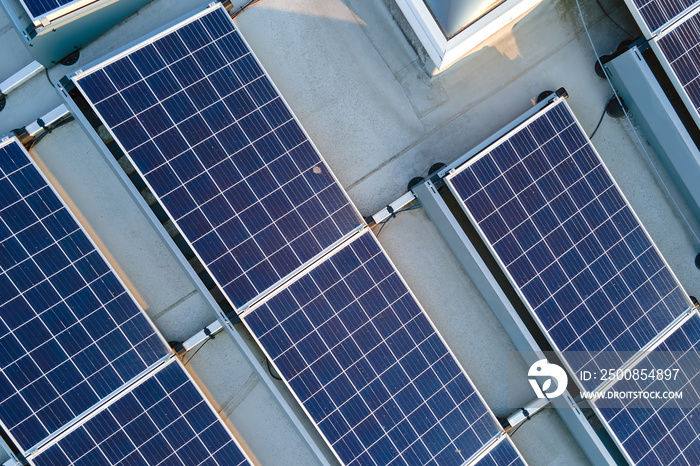 Aerial view building roof with rows of blue solar photovoltaic panels for producing clean ecological electric energy. Renewable electricity with zero emission concept