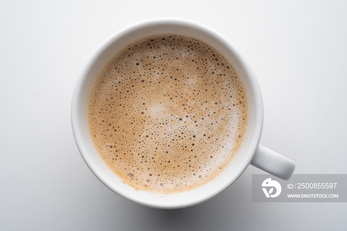 White cup of coffee in soft light isolated on a white background. Cappuccino coffee. Top view