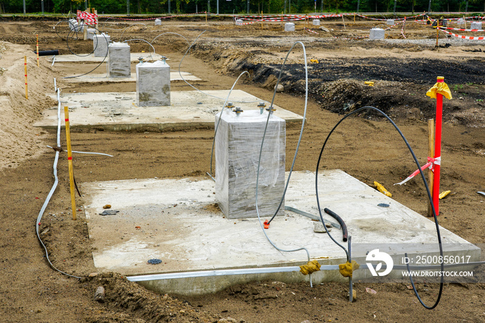 Row of concrete footings for steel columns at the construction site of a new industrial building