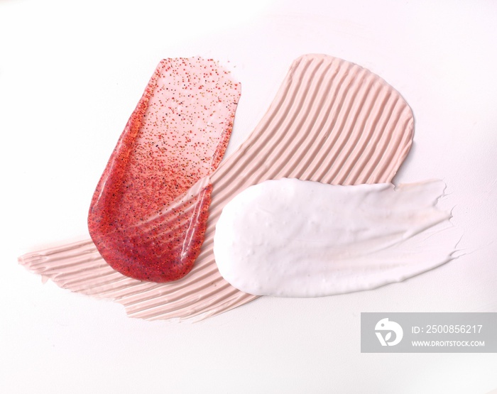 Closeup shot of a makeup smear of a creamy luminous blusher on a pink background