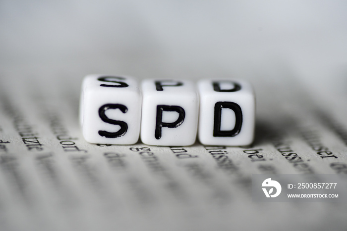 Word SPD formed by wood alphabet blocks on newspaper german party politics