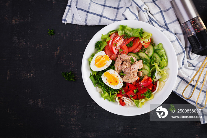 Tuna fish salad with lettuce, tomatoes, cucumber, boiled egg and sweet pepper. Healthy food. French cuisine. Top view, copy space, flat lay