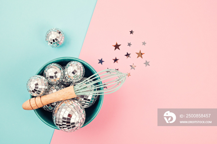 Flat lay with disco balls in the bowl with whisk. Party, fun, celebration planning concept