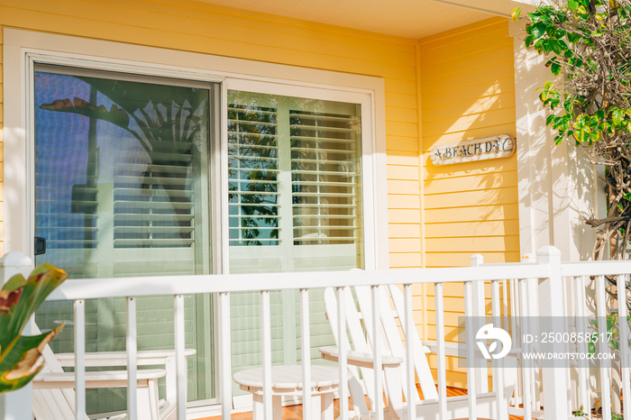 The white wooden table and white wooden chairs on the balcony or terrace in the sunlight in small beach town