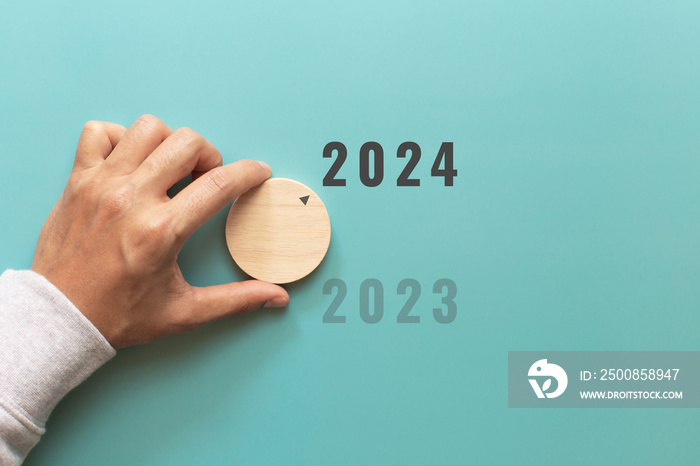 Man hand choose number 2024 on blue background. countdown to 2024. Start concept