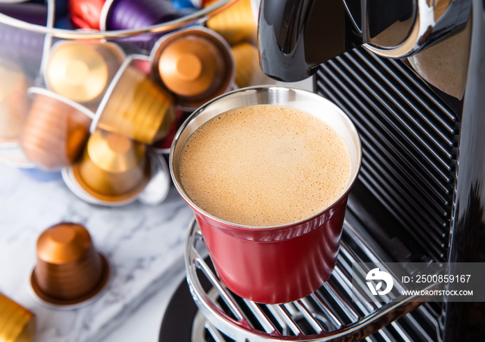 Espresso cup with pods capsules and home coffee machine on white background.