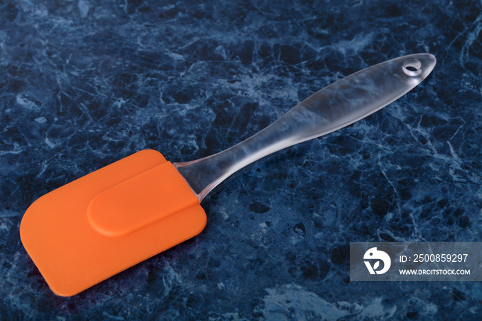 Orange silicone spatula with transparent handle.