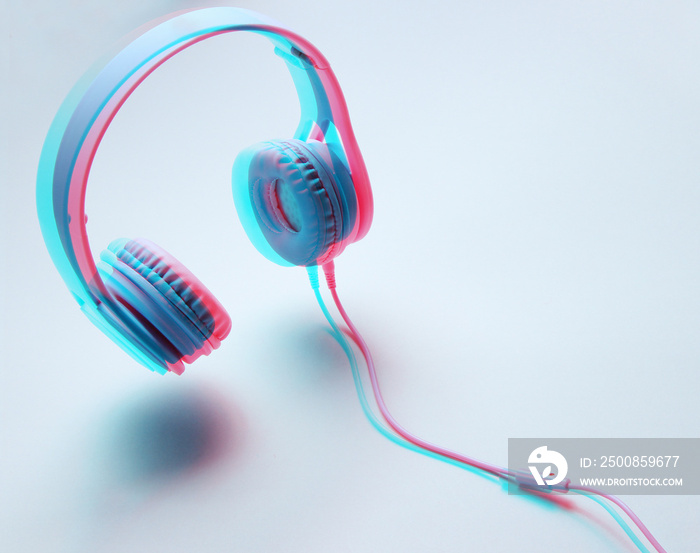 3D surround photo modern blue headphones with cable on gray background. Glitch effect