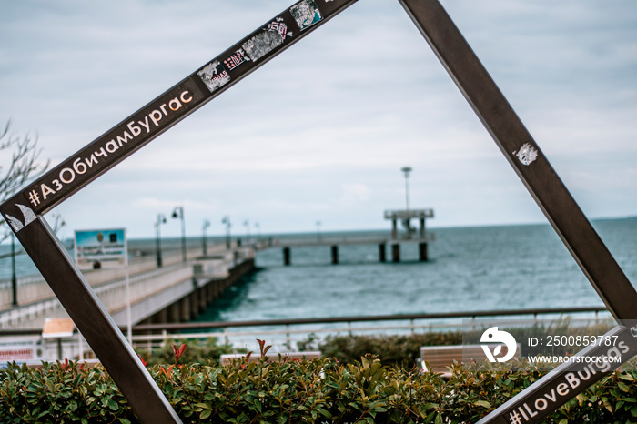 A picture frame monument and the symbol of Burgas - Burgas sea bridge in the background. Translation on the frame is I Love Burgas.