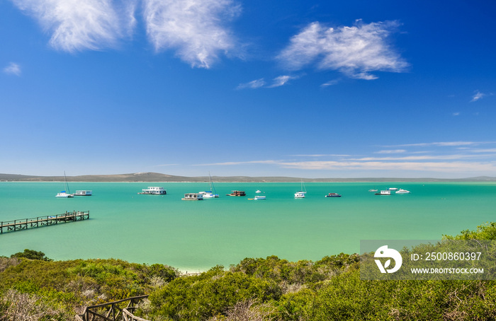 Stunning view of Langebaan Lagoon in West Coast National Park,120 km north of Cape Town, Western Cape Province, South Africa. Sunny day, house boats, a jetty and mountains in the background.