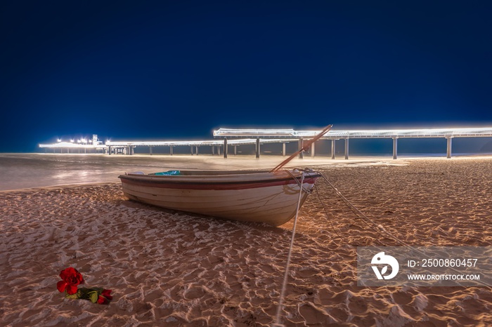 Ostsee,  wunderschöne Seebrücke Koserow auf der Insel Usedom bei Nacht mit Fischerboot im Vordergrund