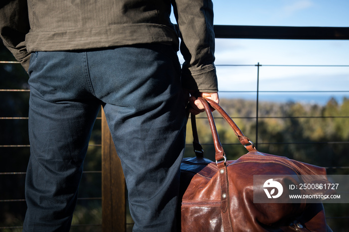 A man holding a leather bag