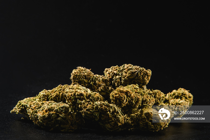 Pile of marijuana buds on a black background.