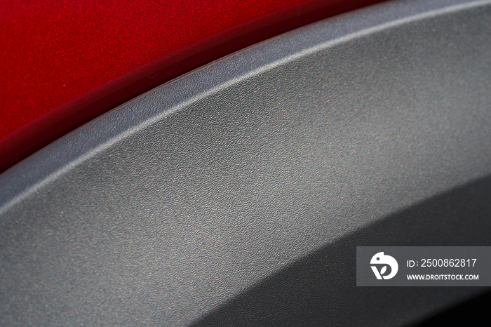 Close up detail of red metallic paint coating and carbon mat grey wrap car body