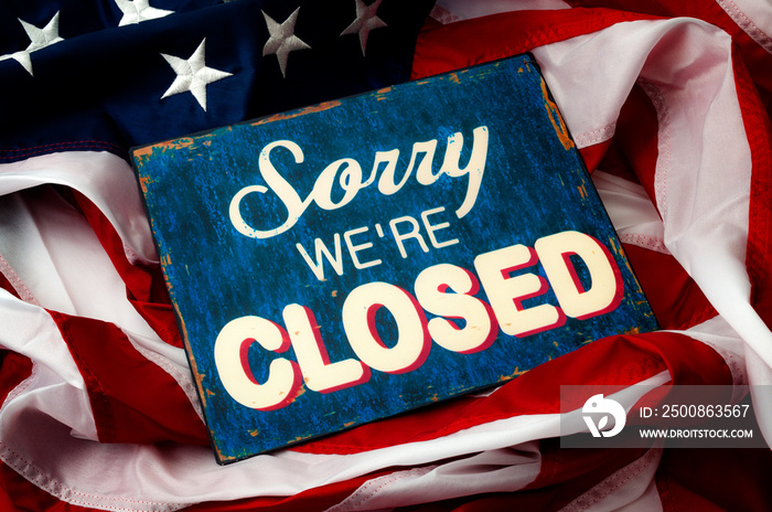 Government shutdown, Washington is broken, political deadlock and partisan politics concept theme with a sorry we’re closed sign and the American flag