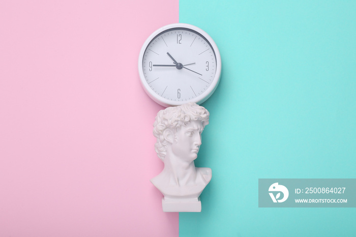 David bust with clock on pink blue background. Creative layout. Concept pop. Minimal still life. Flat lay. Top view