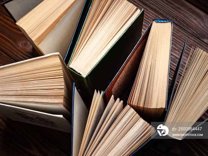 Old books . A stack of old open books stacked on a table.