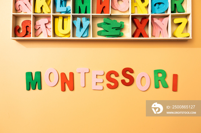 the word montessori represented as a concept by wooden color letters over a background