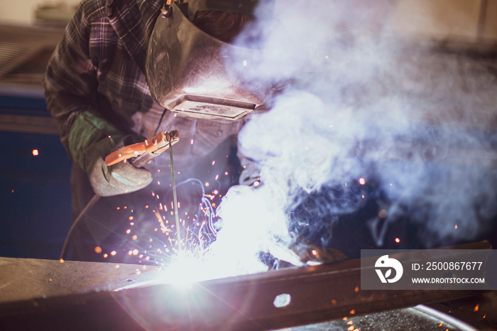 welder performing his work at a stationary post for electric arc welding