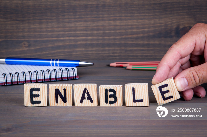 Enable. Wooden letters on dark background. Office desk