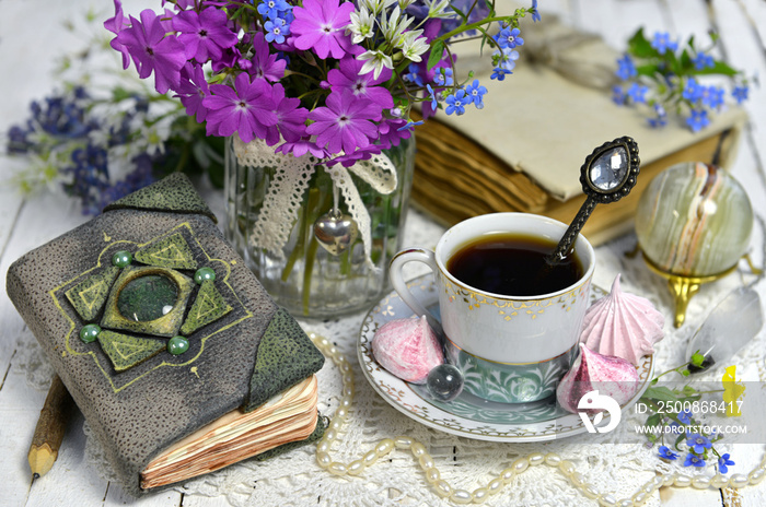 Still life with adorable hand crafted diary, tea cup and wildflowers. Vintage background with old book and flowers, romantic concept