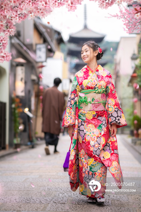 Japanese girl walk in kyoto old market and wooded yasaka pagoda with sakura flower background