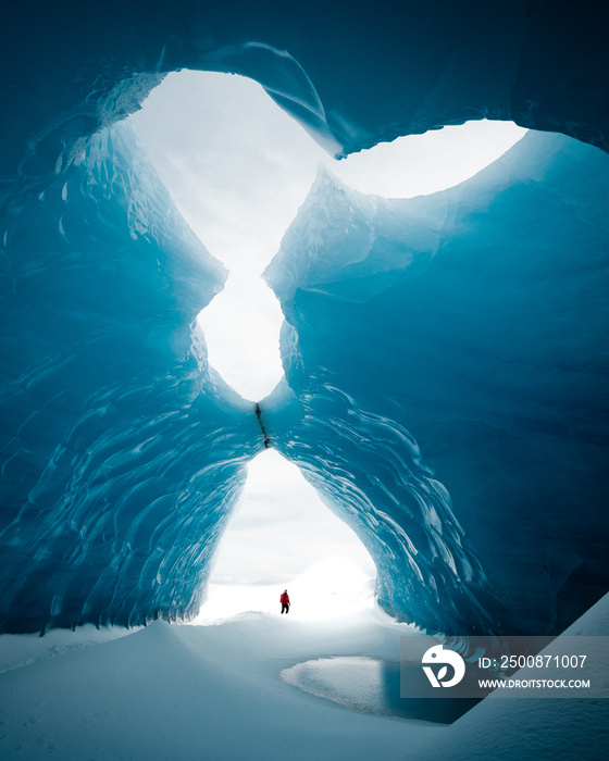 Person is standing in beautiful ice cave in Vatnajkull glacier Iceland in the winter