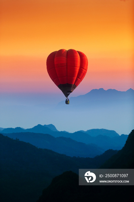 single red hot air balloons flying over blue mountains landscape