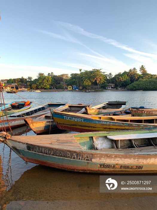 Wooden boats over calm river at sunset