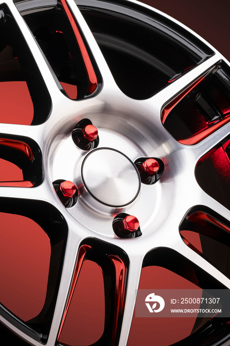 a fragment of red alloy wheels, spokes, wheel nuts and details of a sports car wheel close-up on a red background , a symbol of auto tuning of a car service or sports racing