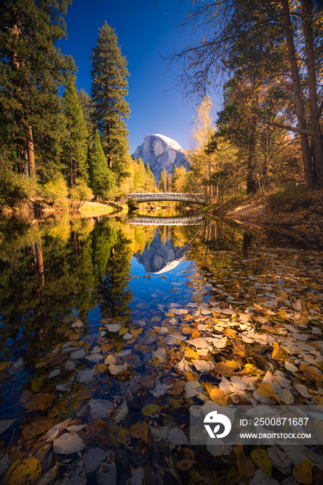 Yosemite Valley river with reflection of Half-Dome and autumn trees