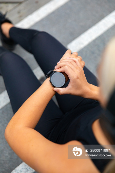 Woman runner setting up the fitness smart watch for running