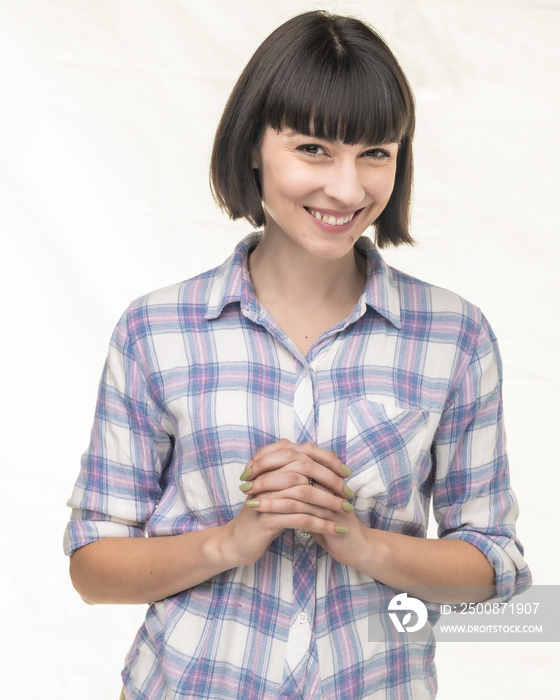 Woman with bobbed hair in plaid shirt expresses in a studio environment.