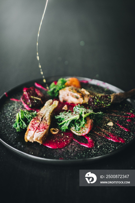 Michelin restaurant serving organic duck meat with kale and Beet puree on dark plate, chef cooking food