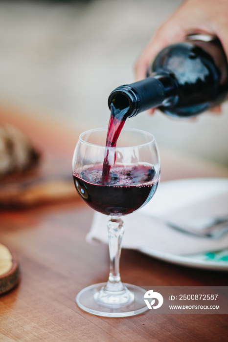 Close Up of Hand Pouring Wine