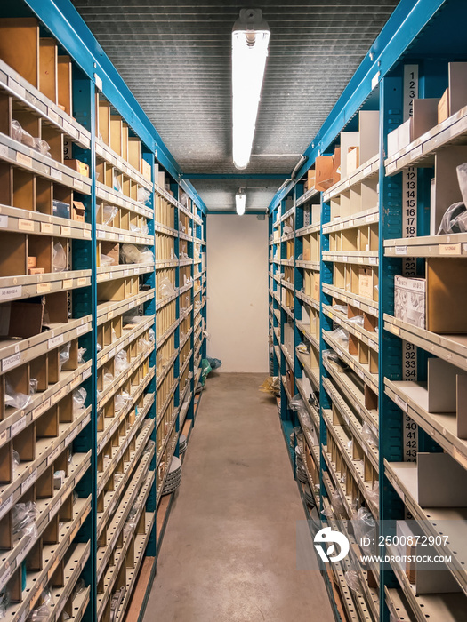 many shelves filled with spare parts stand in the parts store of a car repair shop