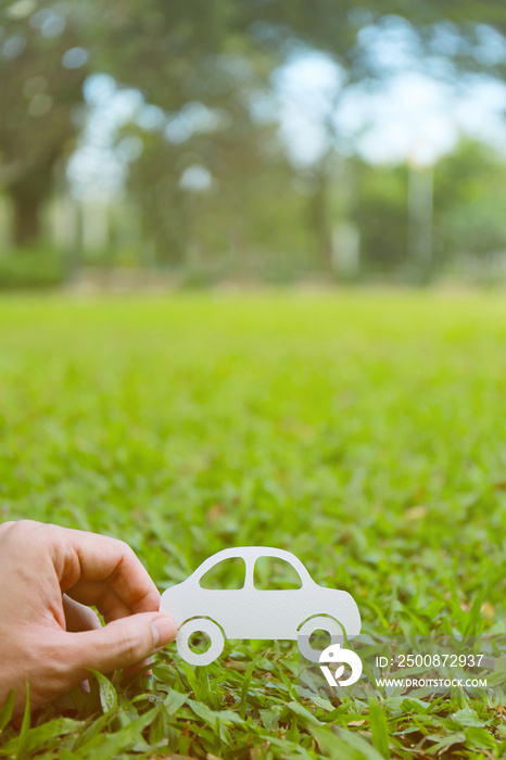 Paper cut of car on green grass background, earth day concept, spring time