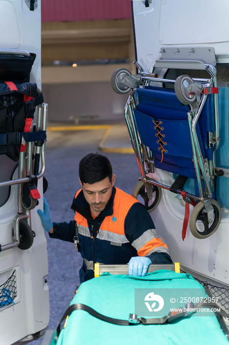 vertical photo of a young paramedic entering the ambulance to get the stretcher out. stock photography