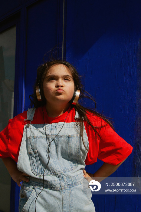 Young curvy woman with Down Syndrome listening to music