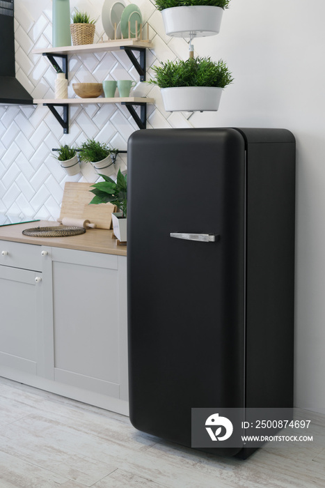 Black retro design fridge in white wooden kitchen