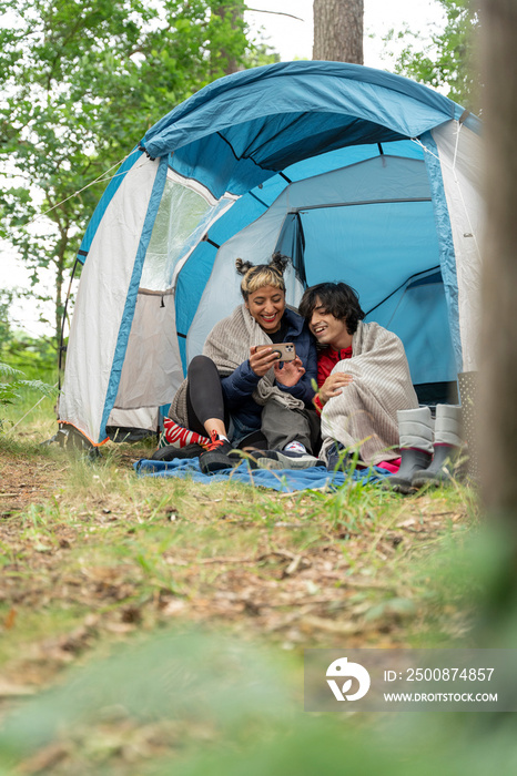 Mother and son using phone in tent