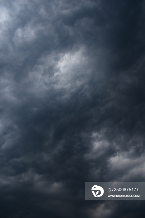 Dark rainy twisted thunderstorm clouds grey color vertical image