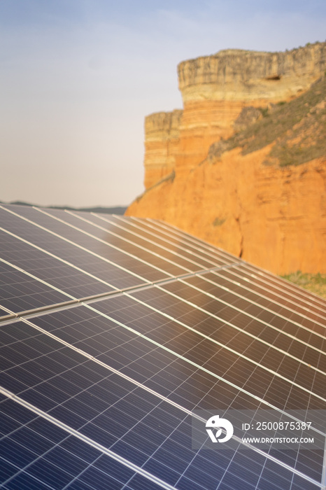 A solar panel in blue and yellow tones generating green electricity in a blue environment