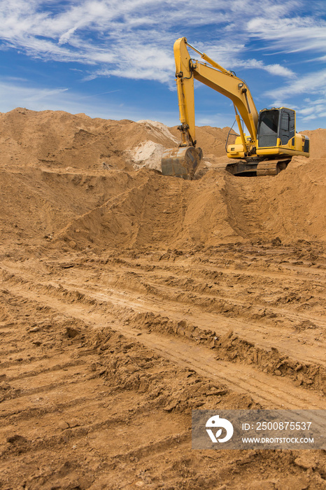 Backhoe on the sand against the sky.