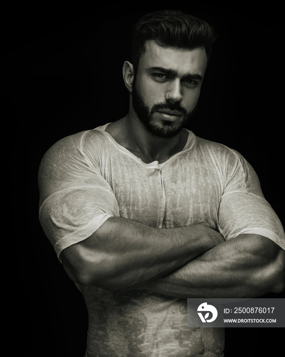 Portrait of handsome male fitness model crossing his arms