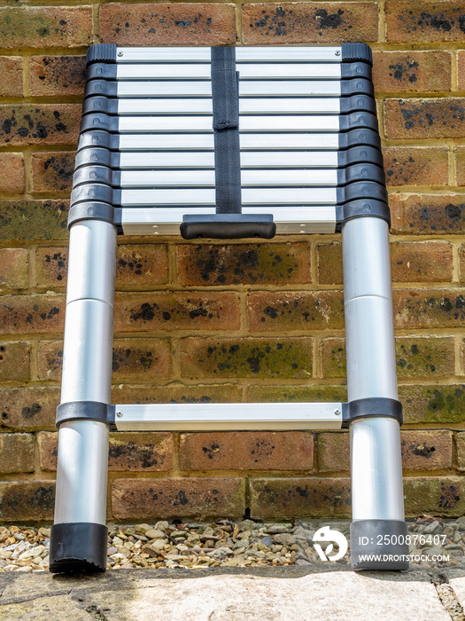 Aluminium tubular section telescopic access ladder collapsed down for storage