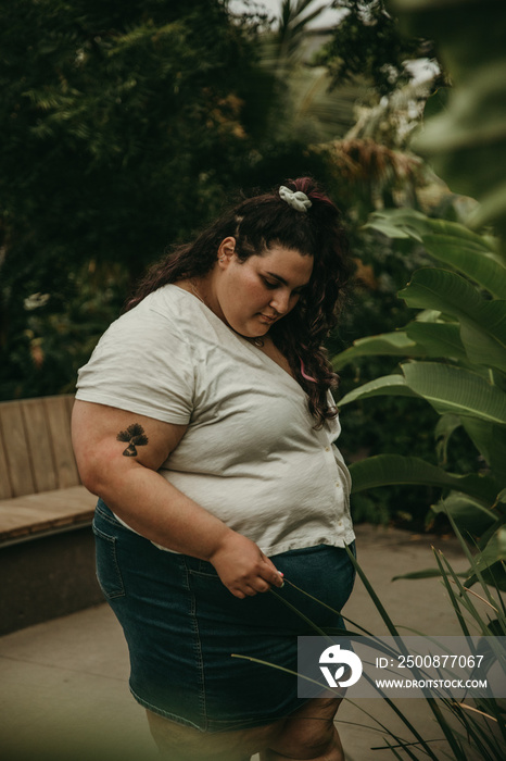 portrait of a plus size Jewish woman looking at plants