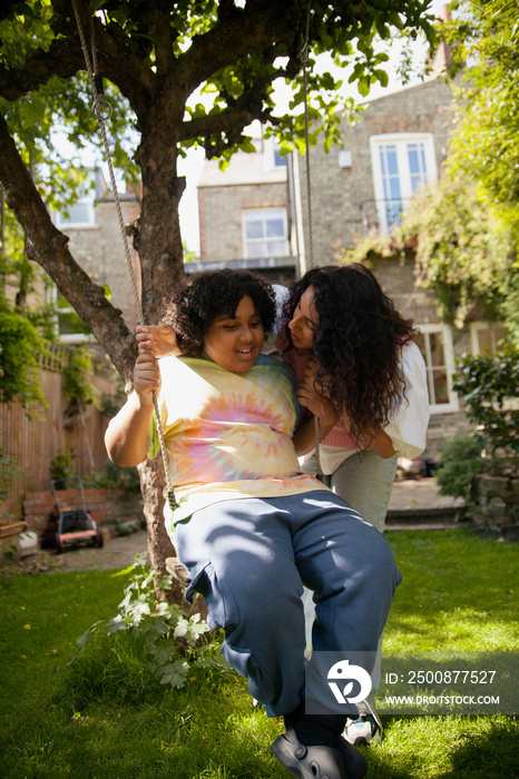 Mid-sized mother smiling at her plus-sized son in the garden