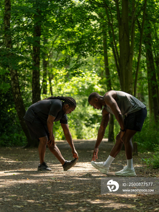 Two men stretching in forest